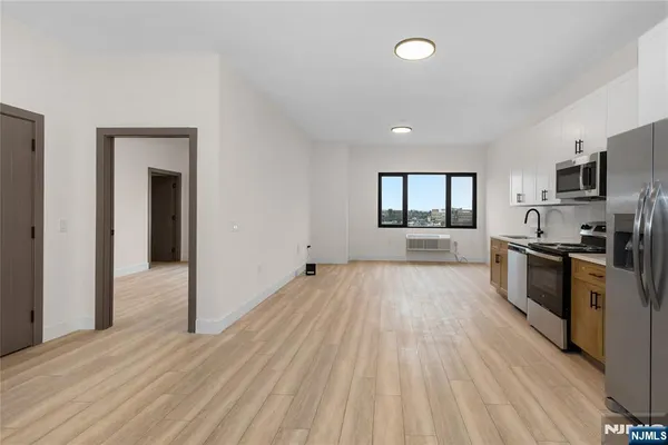 a large space with kitchen view and stainless steel appliances