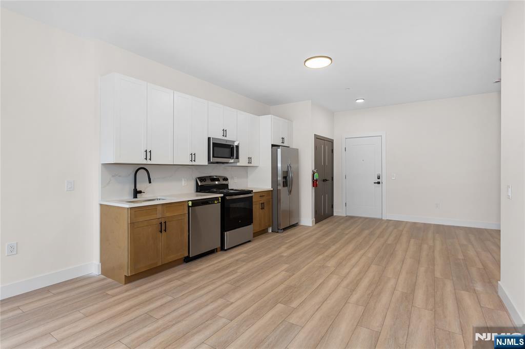 89 Mary Street, Unit 503 Paterson, NJ 07503 - Photo 3 of 14 a kitchen with stainless steel appliances a refrigerator sink and stove