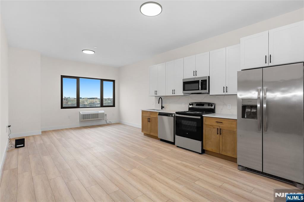 89 Mary Street, Unit 503 Paterson, NJ 07503 - Photo 5 of 14 a kitchen with stainless steel appliances granite countertop a stove a sink and a refrigerator