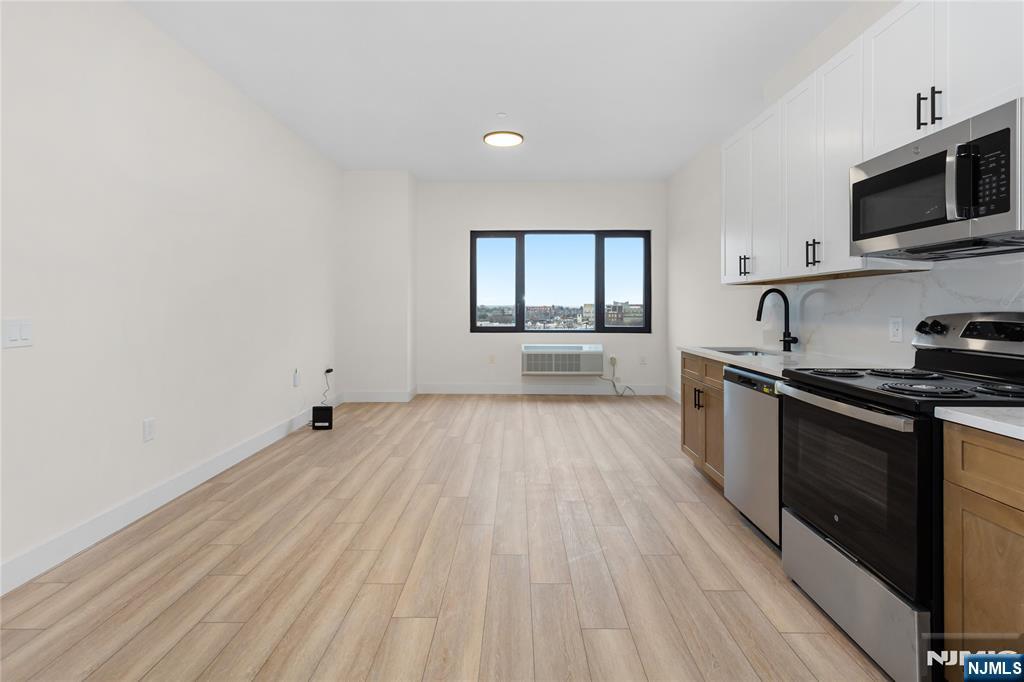 89 Mary Street, Unit 503 Paterson, NJ 07503 - Photo 6 of 14 a kitchen with granite countertop a stove top oven and sink