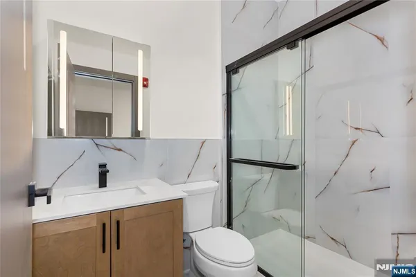 a bathroom with a sink a toilet and shower