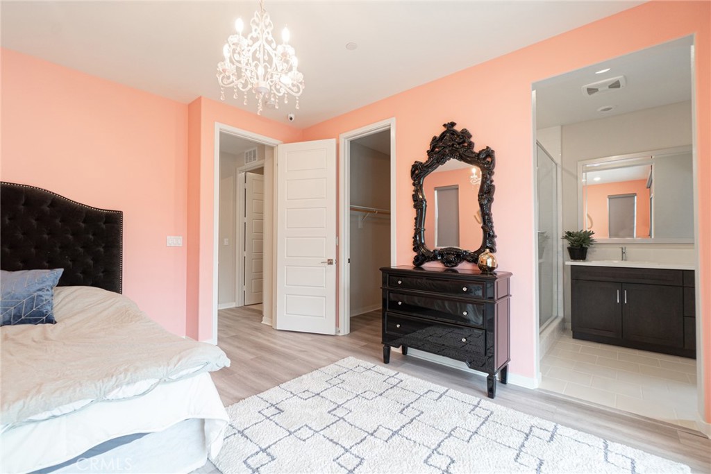 185 Tribeca Irvine, CA 92612 - Photo 21 of 55 a bedroom with a bed and a chandelier