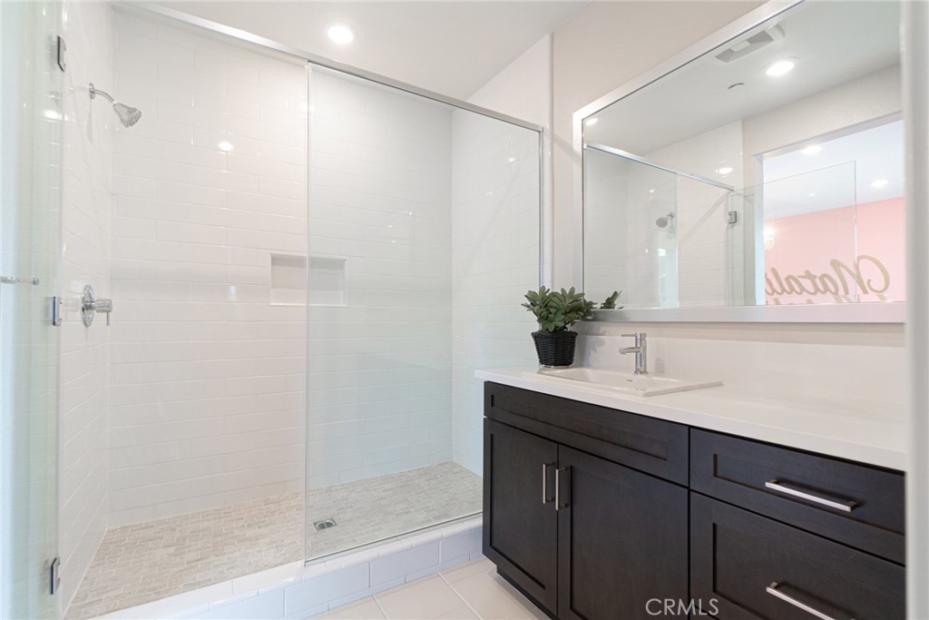 185 Tribeca Irvine, CA 92612 - Photo 25 of 55 a bathroom with a sink shower and a mirror
