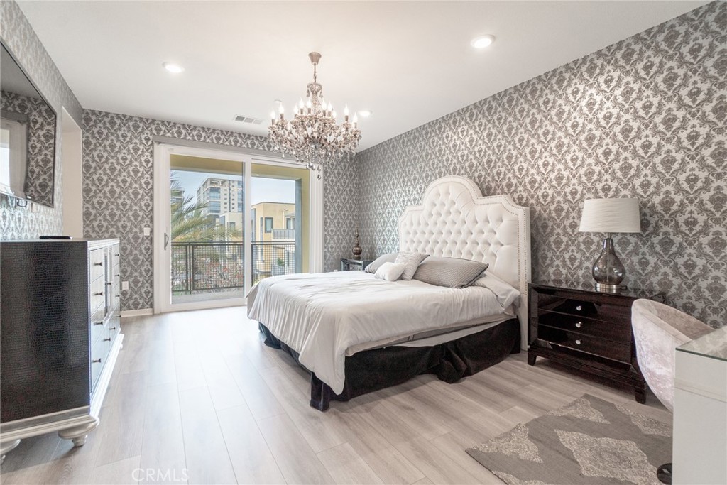 185 Tribeca Irvine, CA 92612 - Photo 27 of 55 a spacious bedroom with a bed and a chandelier