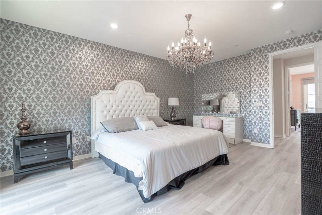 185 Tribeca Irvine, CA 92612 - Photo 28 of 55 a bedroom with a bed and a chandelier