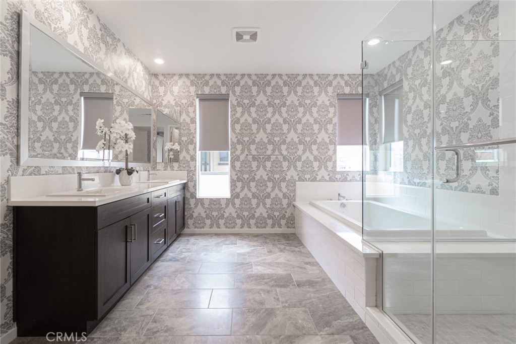 185 Tribeca Irvine, CA 92612 - Photo 30 of 55 a large bathroom with a double vanity sink a mirror and a bathtub
