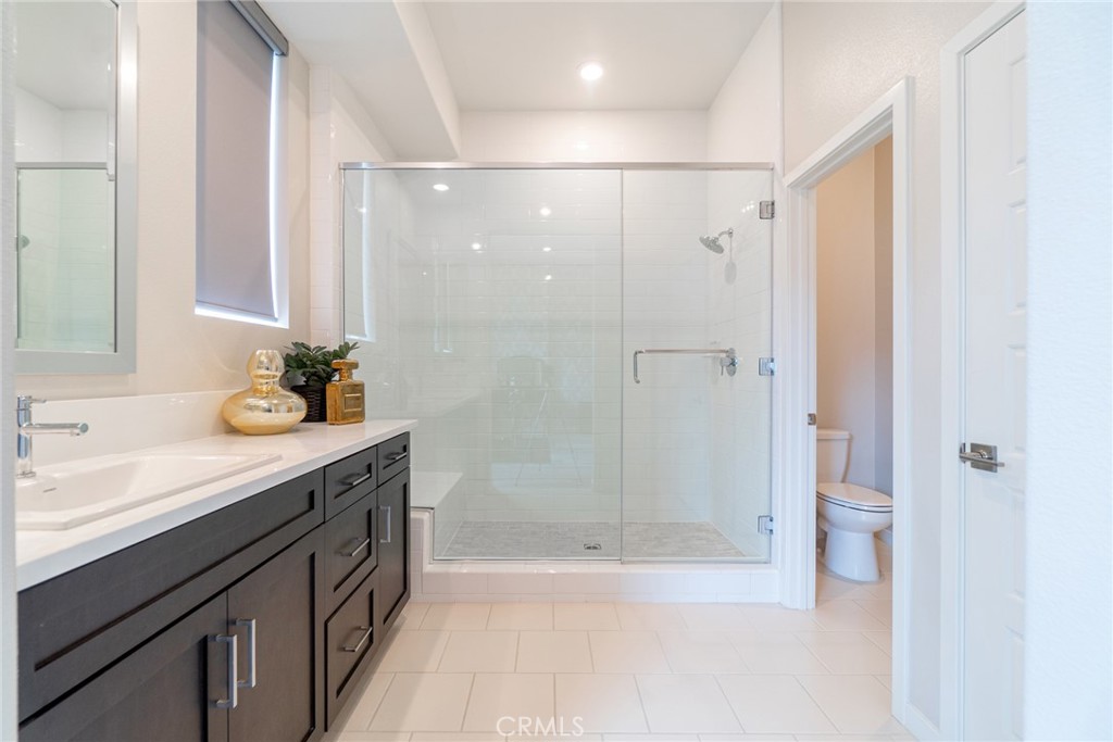185 Tribeca Irvine, CA 92612 - Photo 37 of 55 a bathroom with a shower sink vanity and toilet