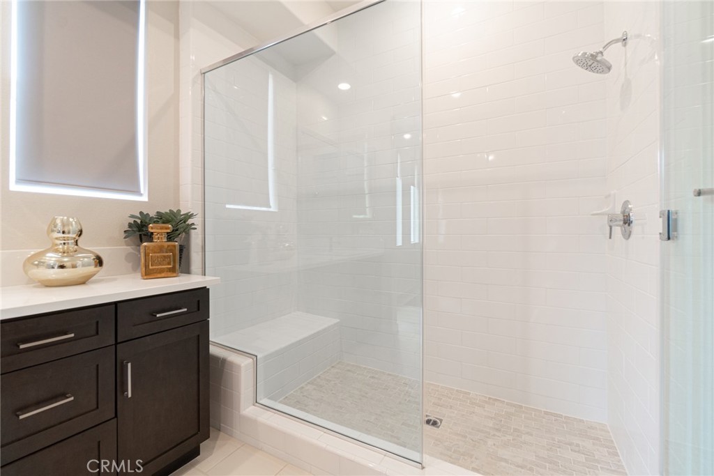 185 Tribeca Irvine, CA 92612 - Photo 38 of 55 a bathroom with a shower sink and mirror