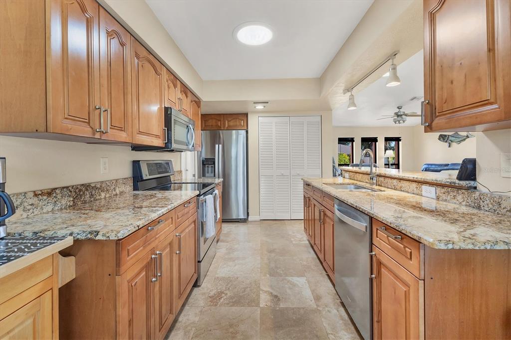 7047 Adderly Road Englewood, FL 34224 - Photo 13 of 39 a kitchen with stainless steel appliances granite countertop a sink a stove and a refrigerator