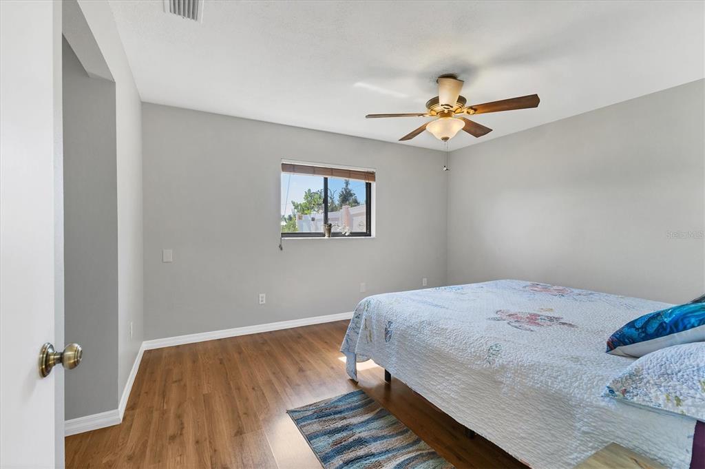 7047 Adderly Road Englewood, FL 34224 - Photo 17 of 39 a bedroom with a bed and a chandelier