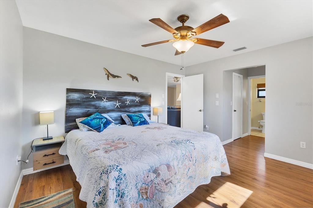 7047 Adderly Road Englewood, FL 34224 - Photo 18 of 39 a bedroom with a bed and a chandelier