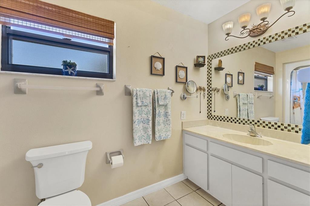 7047 Adderly Road Englewood, FL 34224 - Photo 19 of 39 a bathroom with a toilet a sink and mirror