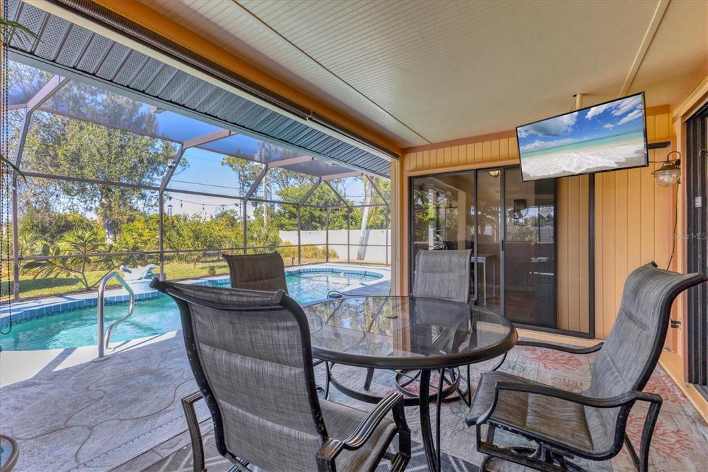 7047 Adderly Road Englewood, FL 34224 - Photo 24 of 39 a view of a dining room with furniture wooden floor and a floor to ceiling window
