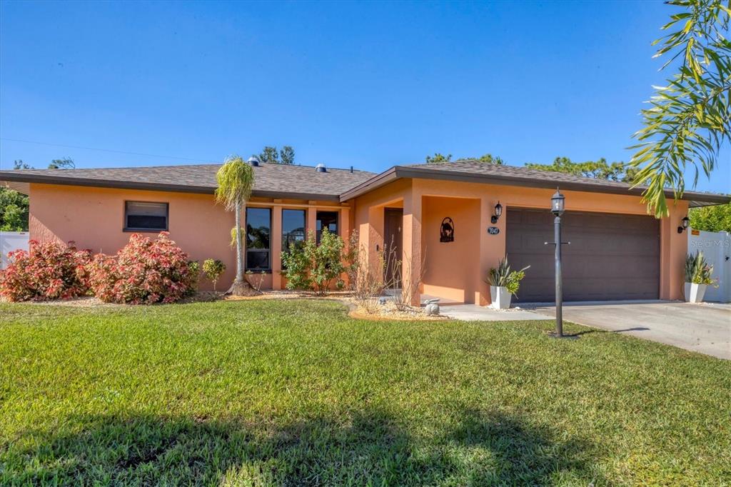 7047 Adderly Road Englewood, FL 34224 - Photo 3 of 39 a front view of a house with a yard