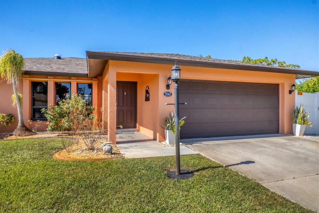 7047 Adderly Road Englewood, FL 34224 - Photo 4 of 39 a front view of a house with a yard