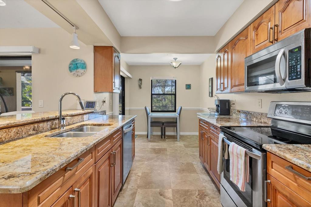 7047 Adderly Road Englewood, FL 34224 - Photo 10 of 39 a kitchen with stainless steel appliances granite countertop a sink and stove