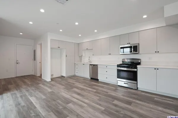 a kitchen with stainless steel appliances a stove microwave and sink