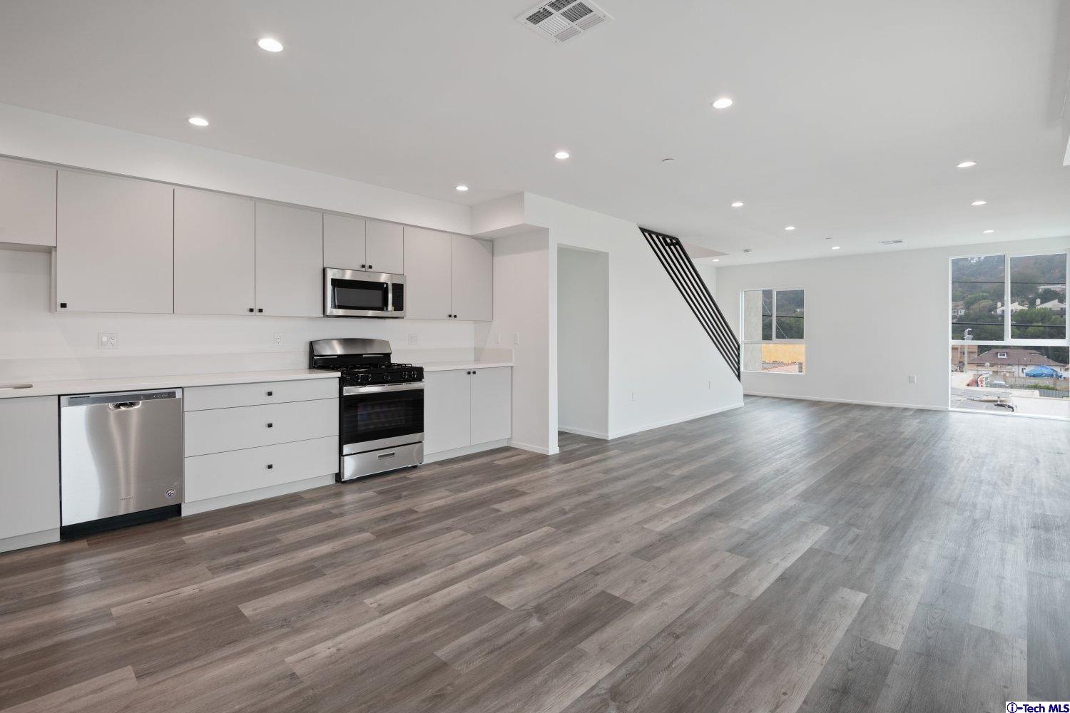 7064 Greeley Street, Unit 105 Tujunga, CA 91042 - Photo 23 of 46 a large kitchen with stainless steel appliances granite countertop a stove a sink and a refrigerator