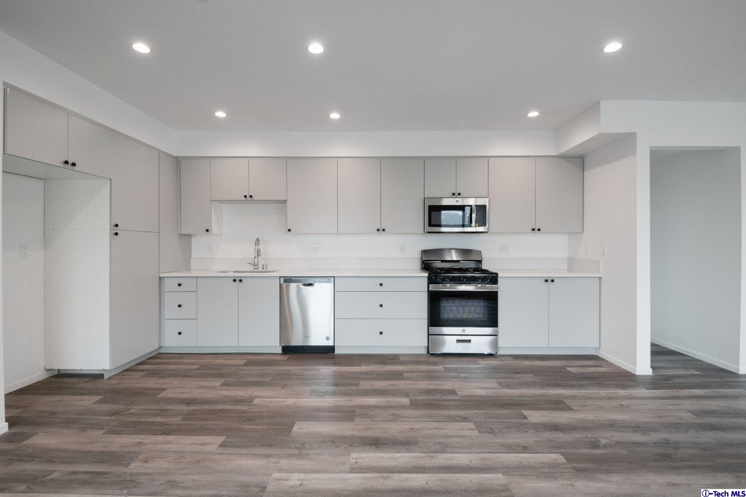 7064 Greeley Street, Unit 105 Tujunga, CA 91042 - Photo 24 of 46 a kitchen with stainless steel appliances granite countertop a stove and a refrigerator
