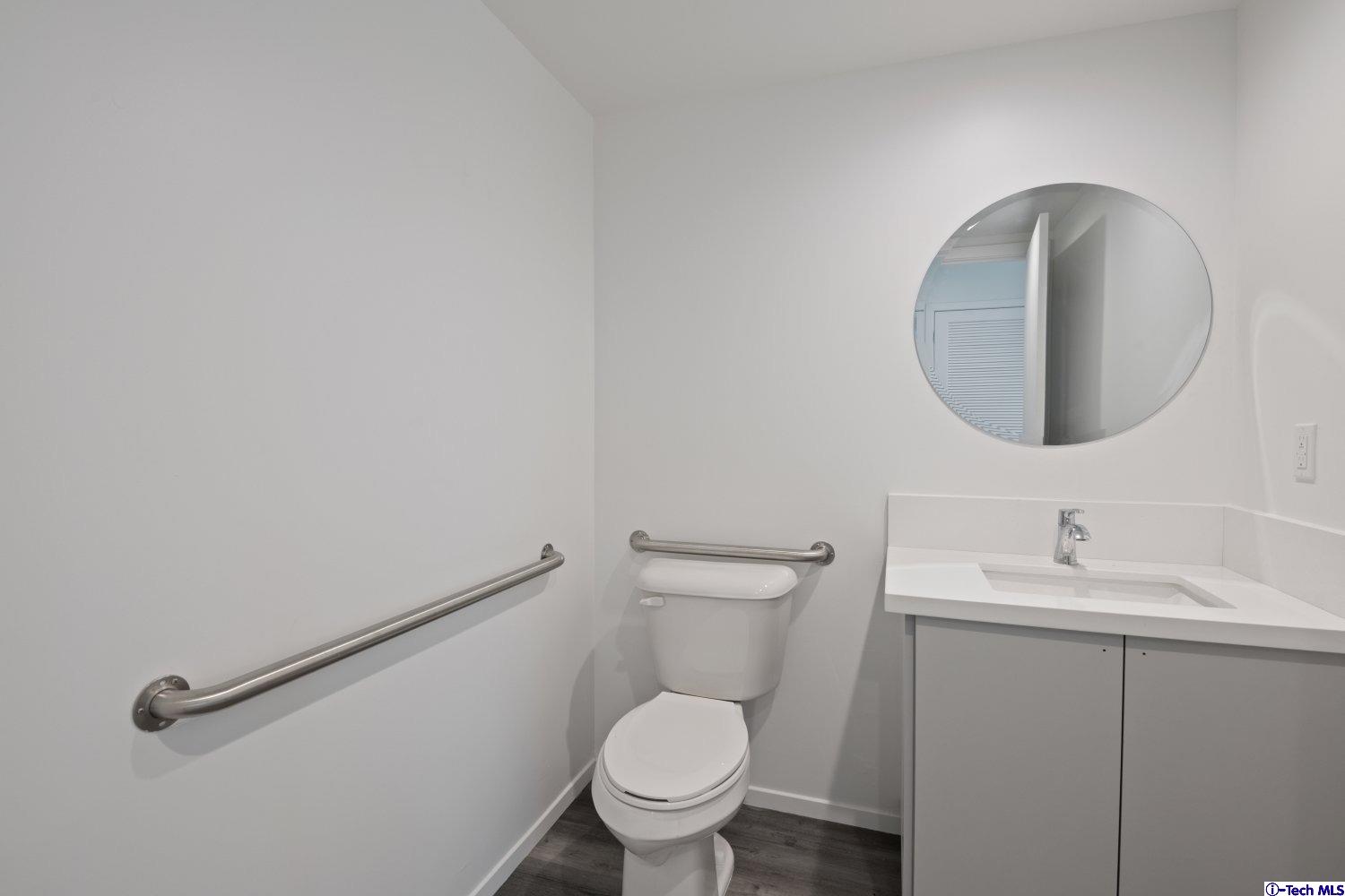 7064 Greeley Street, Unit 105 Tujunga, CA 91042 - Photo 27 of 46 a bathroom with a toilet sink and mirror