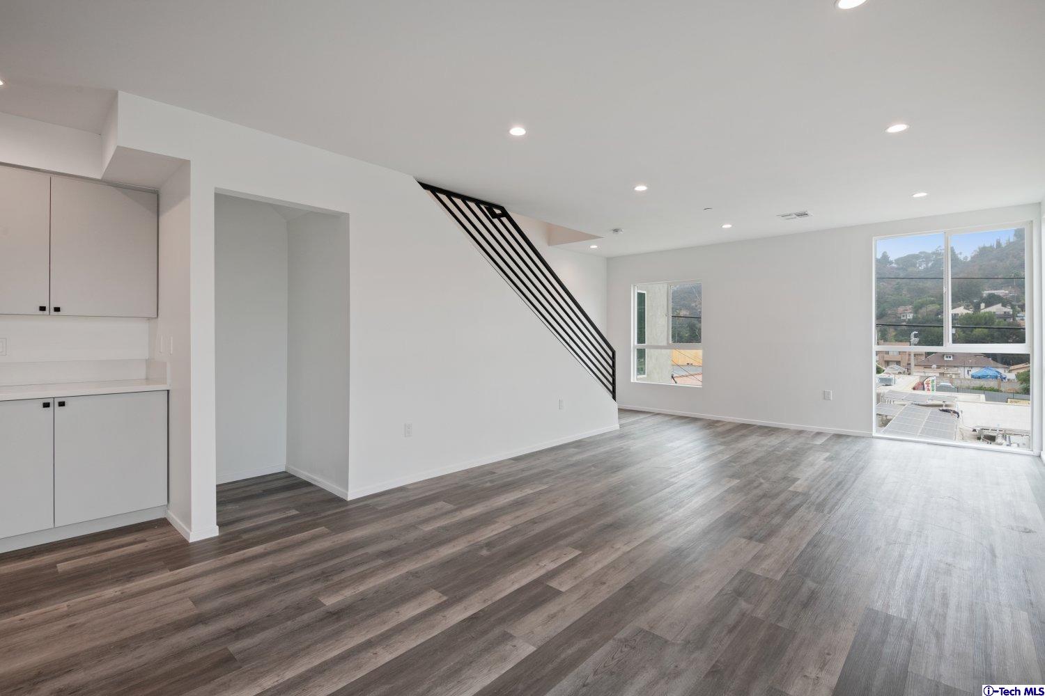 7064 Greeley Street, Unit 105 Tujunga, CA 91042 - Photo 29 of 46 a view of an empty room with wooden floor and a window
