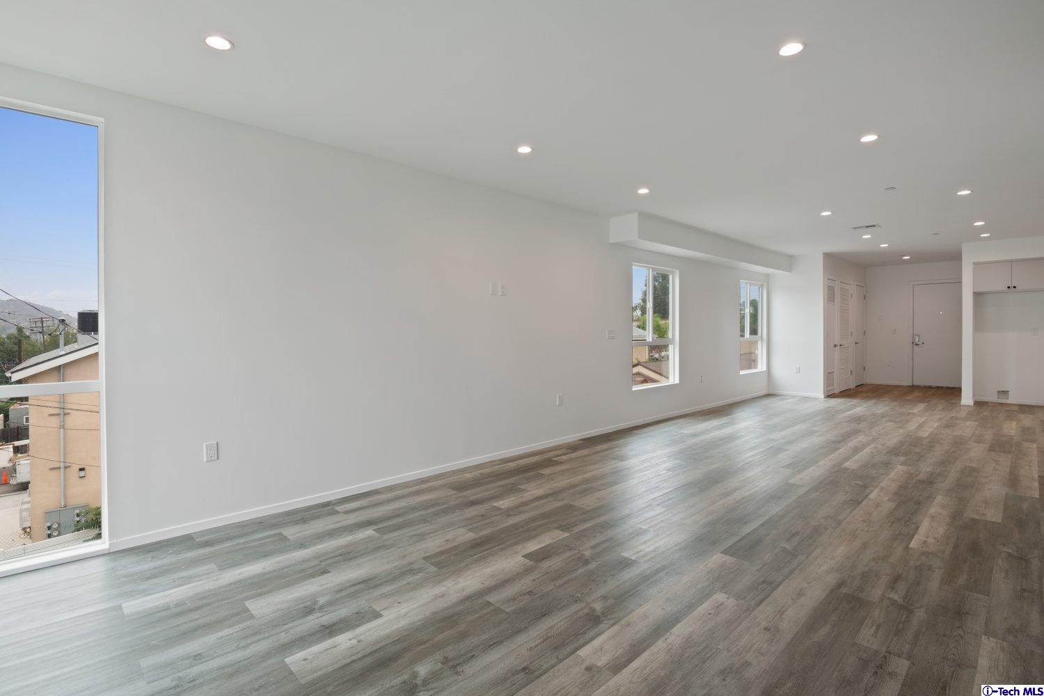 7064 Greeley Street, Unit 105 Tujunga, CA 91042 - Photo 31 of 46 a view of an empty room with wooden floor and a window