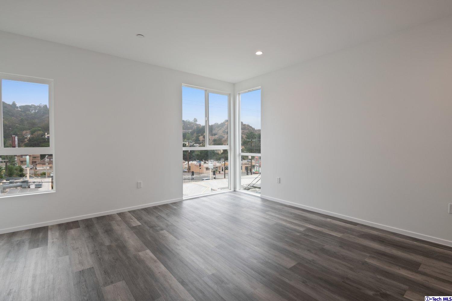 7064 Greeley Street, Unit 105 Tujunga, CA 91042 - Photo 33 of 46 a view of an empty room with a window and wooden floor