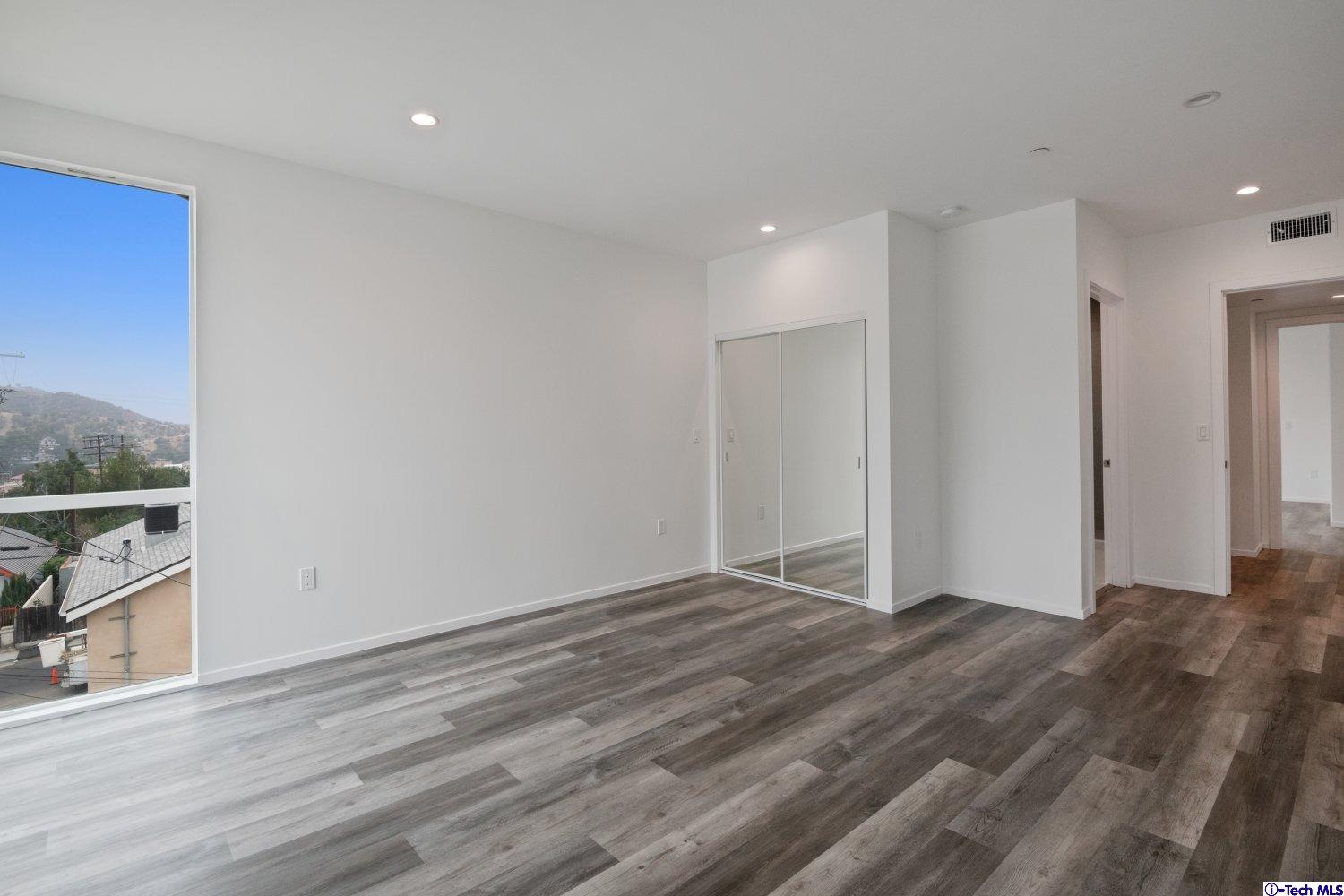 7064 Greeley Street, Unit 105 Tujunga, CA 91042 - Photo 34 of 46 a view of an empty room with wooden floor and a window