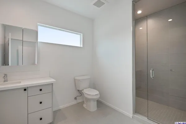 a view of an empty room with wooden floor and closet