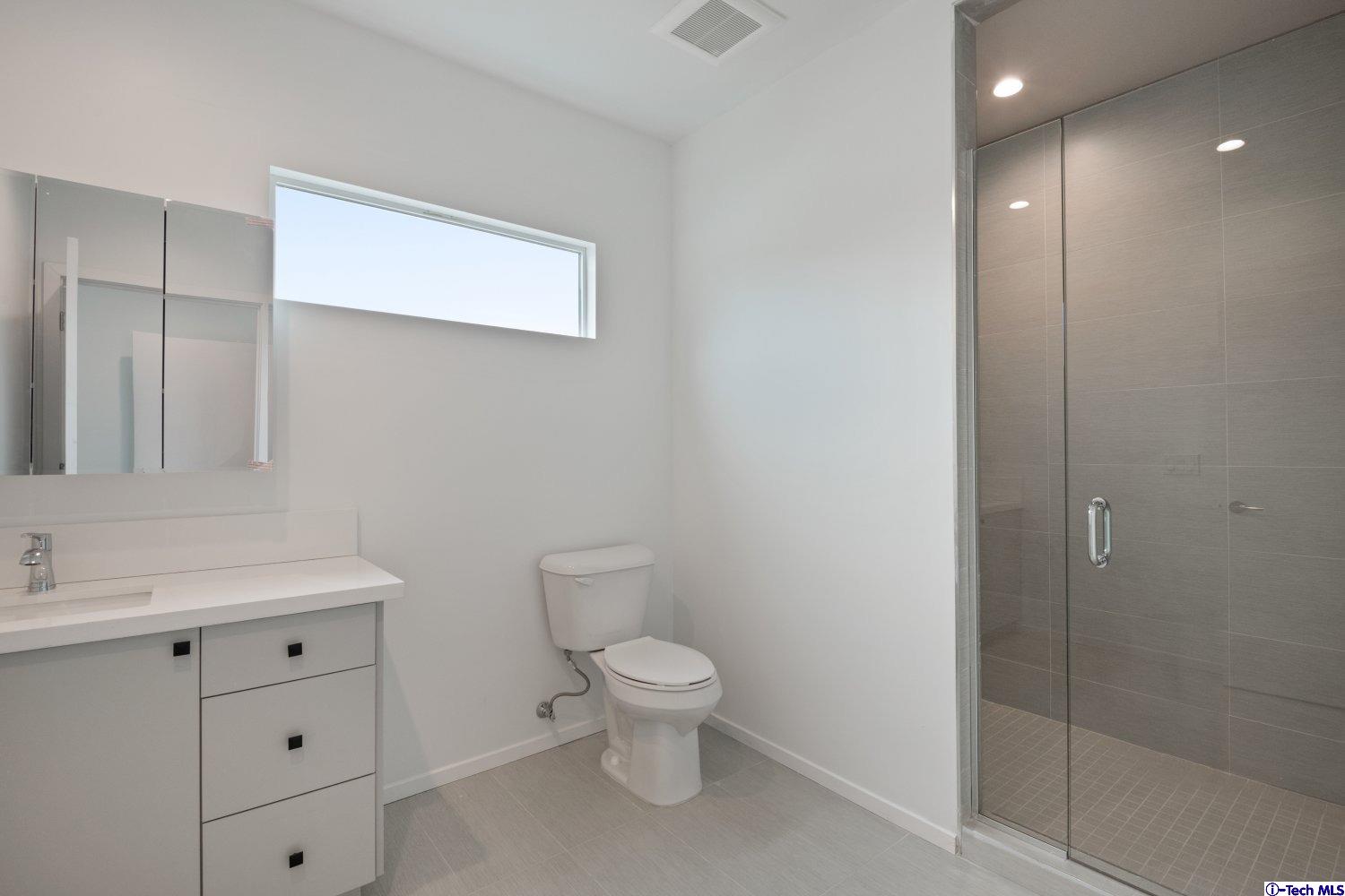 7064 Greeley Street, Unit 105 Tujunga, CA 91042 - Photo 36 of 46 a bathroom with a toilet a sink and mirror
