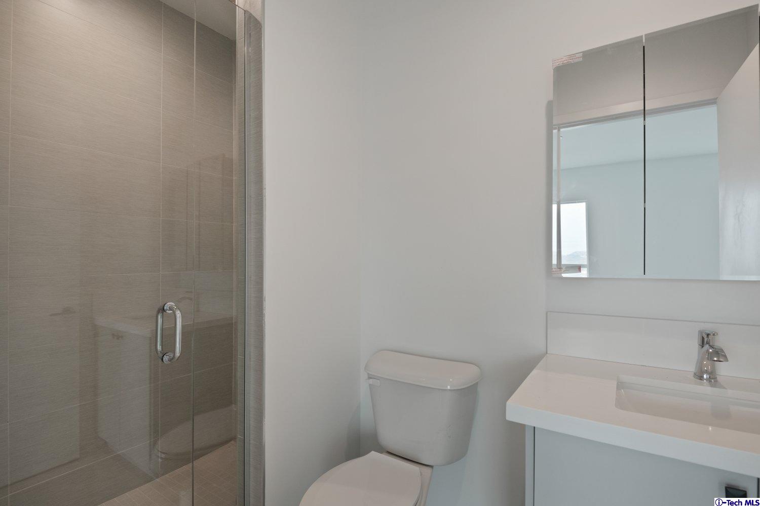 7064 Greeley Street, Unit 105 Tujunga, CA 91042 - Photo 40 of 46 a bathroom with a toilet sink vanity and mirror