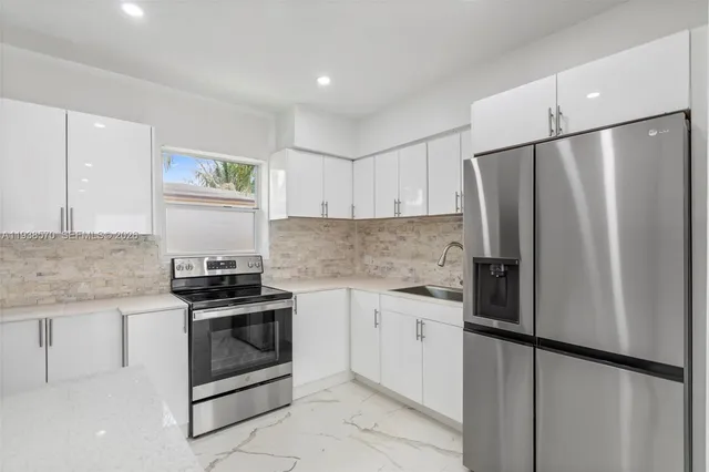 a kitchen with stainless steel appliances granite countertop a refrigerator and a sink