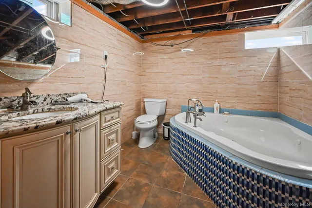 a bathroom with a granite countertop sink a toilet and bathtub