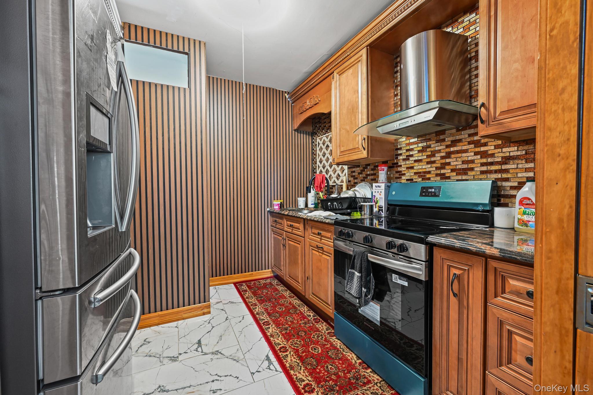 49 Ashley Drive Valley Stream, NY 11580 - Photo 20 of 29 a kitchen with stainless steel appliances granite countertop a stove a sink and a refrigerator