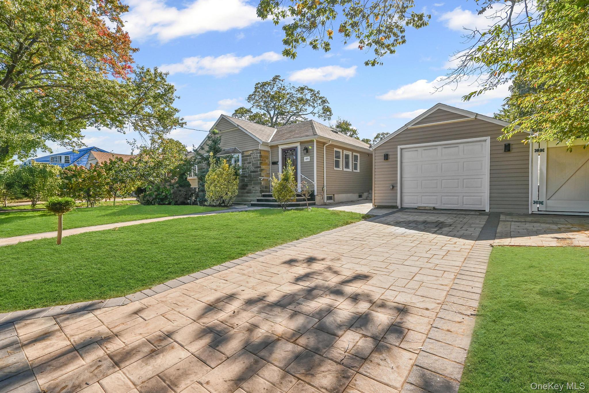 49 Ashley Drive Valley Stream, NY 11580 - Photo 2 of 29 a front view of a house with a yard and garage
