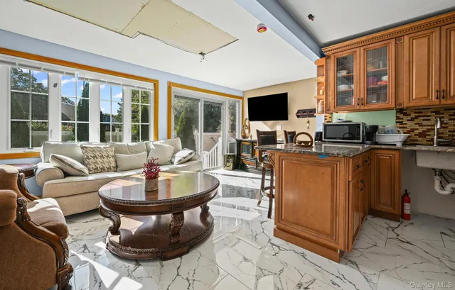 a living room with furniture a flat screen tv and a large window