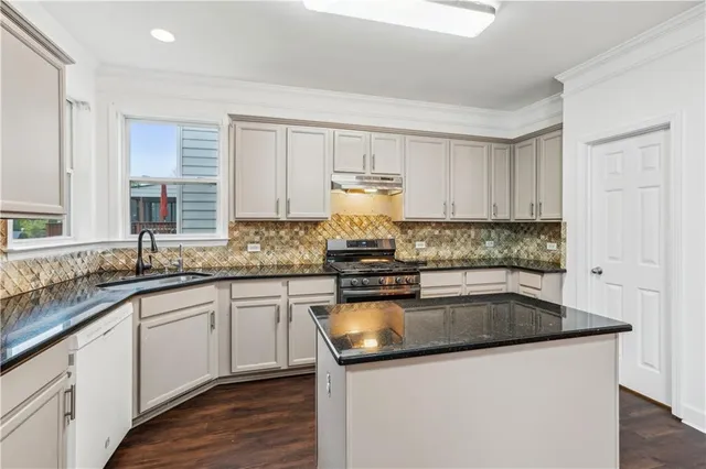 a kitchen with granite countertop a sink and cabinets