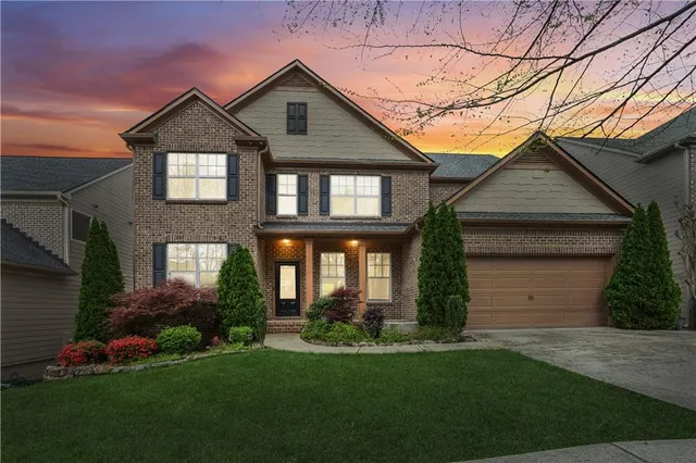 a front view of a house with a garden and plants