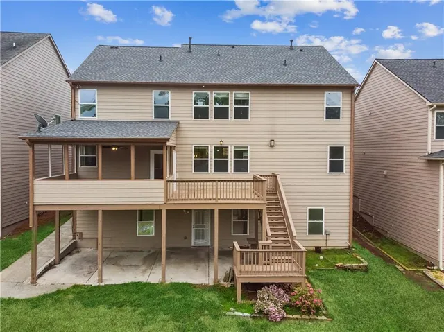 a view of a house with a yard and sitting area
