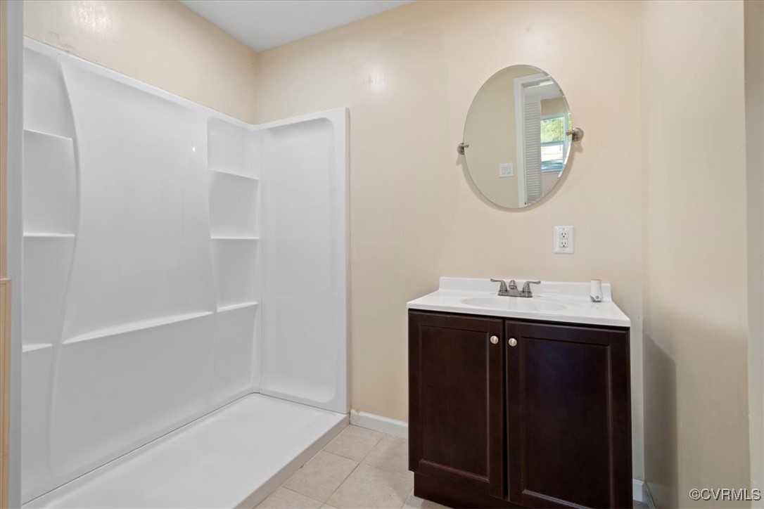 9217 South Quay Road Suffolk, VA 23437 - Photo 46 of 46 a bathroom with a sink a mirror a vanity and a window