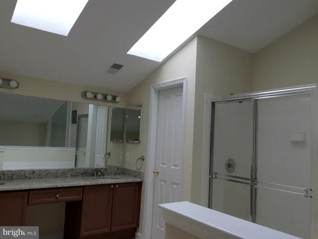 a bathroom with a granite countertop sink mirror and double