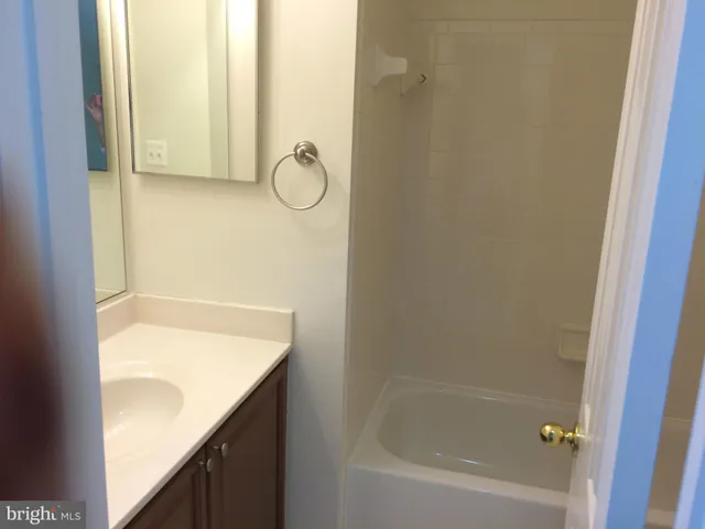 a bathroom with a granite countertop bathtub shower and sink