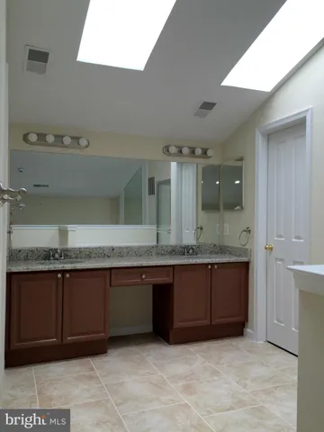 a bathroom with a granite countertop bathtub and double vanity
