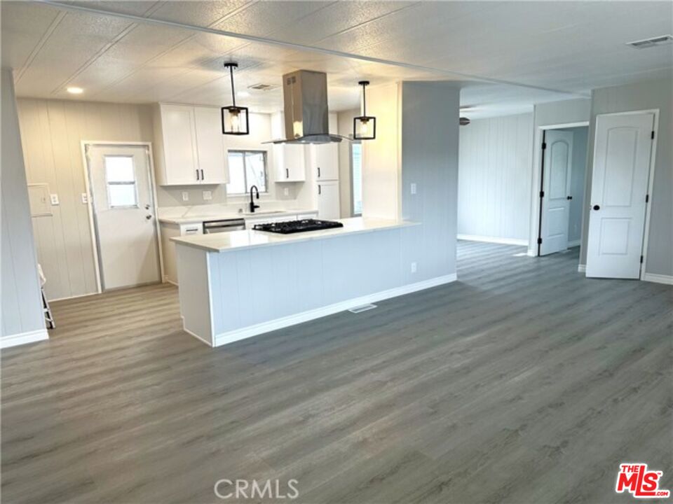 9391 California Avenue, Unit 89 Riverside, CA 92503 - Photo 2 of 16 a large kitchen with cabinets wooden floor and a stainless steel appliances