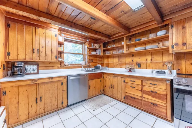 a kitchen with granite countertop a sink and white cabinets