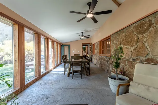a dining room with furniture and a floor to ceiling window