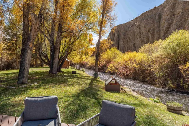 a backyard of a house with swimming pool table and chairs