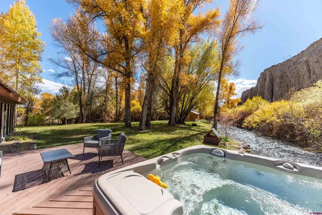 a view of a swimming pool and lounge chairs in back yard