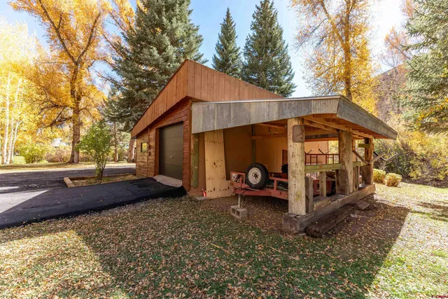 a view of a house with a yard and large trees