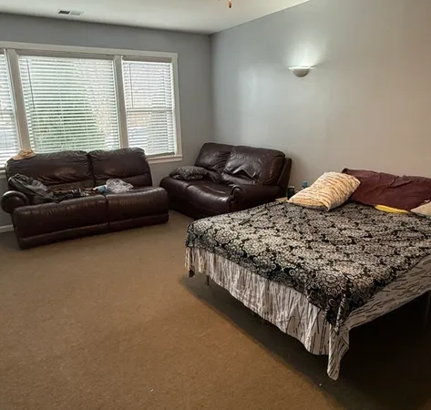 a bedroom with two bed and a couch